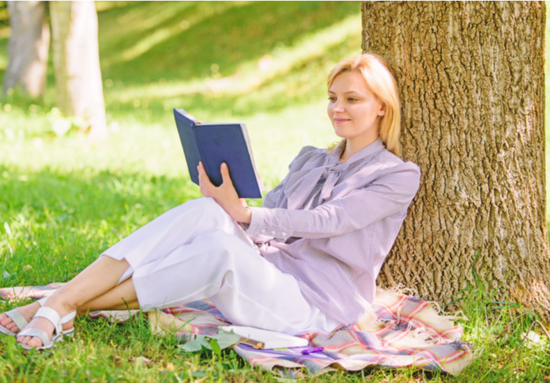 木陰で本を読む女性