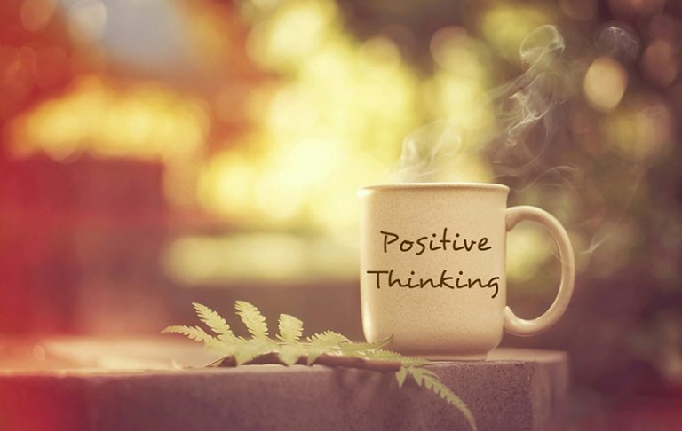 「Positive Thinking」と書かれたマグカップから湯気が立っている