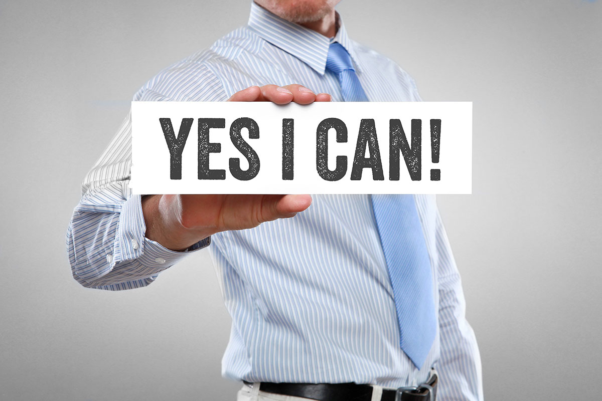 「YES I CAN！」と書かれた紙を持った男性