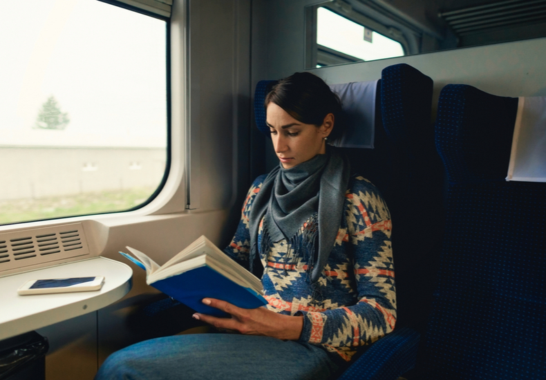 電車で本を読む女性