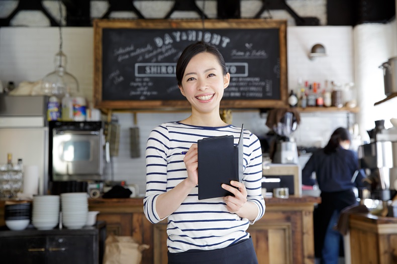 おしゃれなカフェで注文を取る女性店員