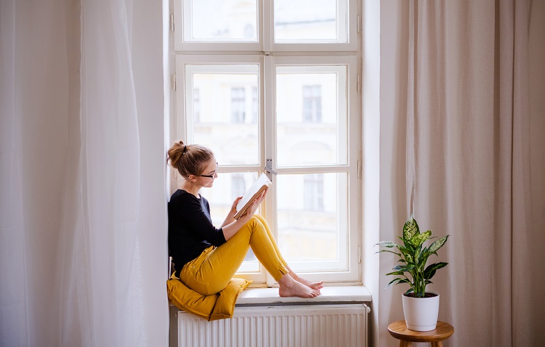 窓辺で読書する女性