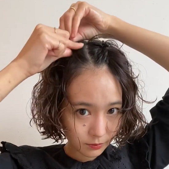 髪に小さなヘアクリップをつける女性
