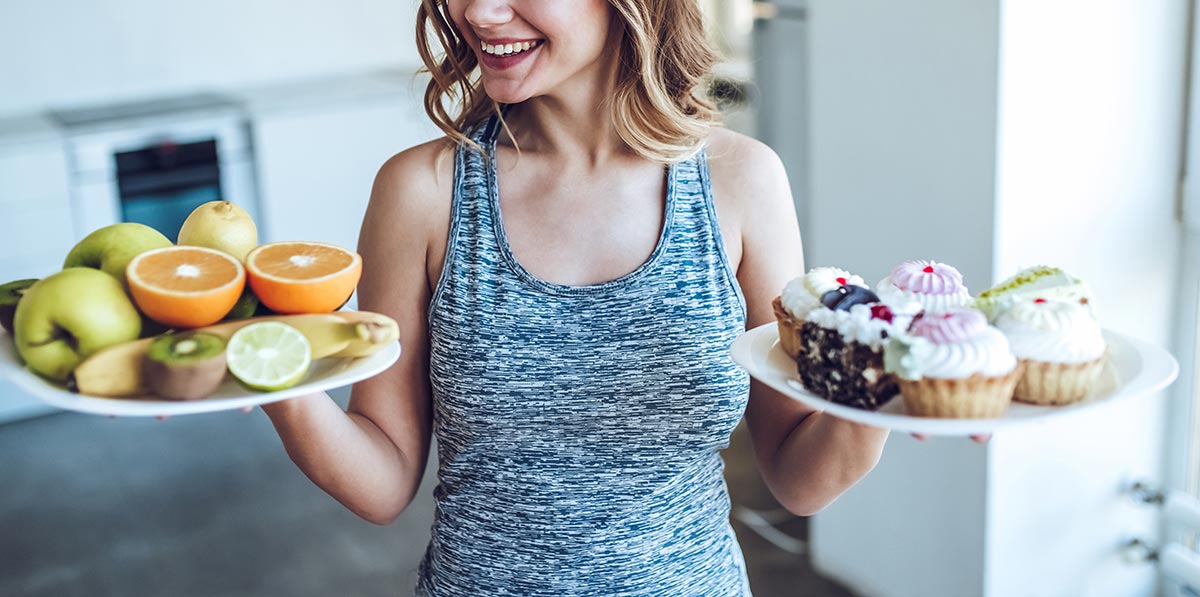 フルーツとケーキを比べる女性