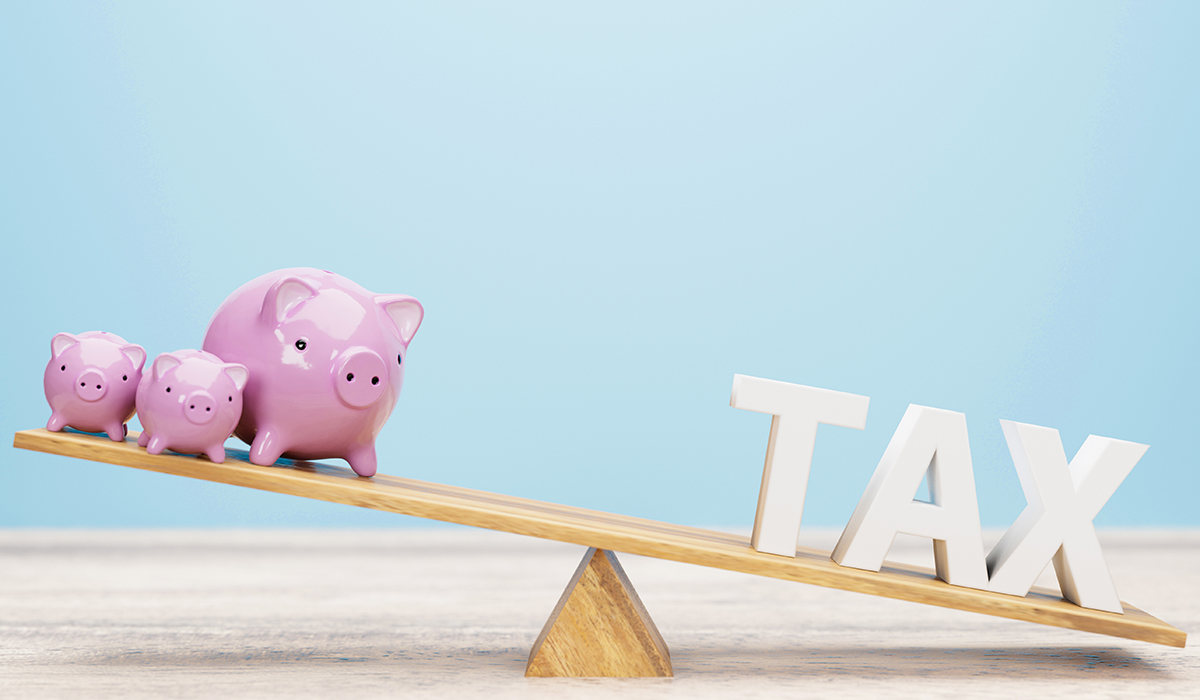 税金のイメージイラスト　豚の貯金箱とTAXの形の積み木がシーソーの両側にそれぞれ置かれている様子