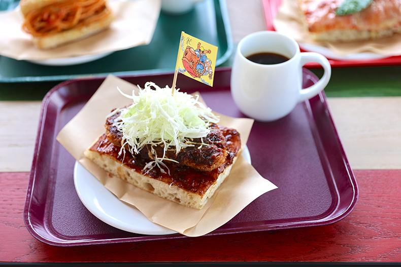 「カフェ 大陸横断飛行」で宮崎駿氏オリジナルデザインの旗が飾られた「しかくいピザ 味噌カツ」正面