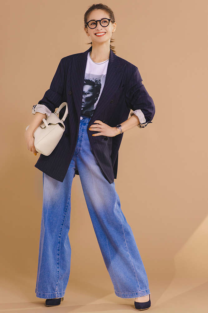 プリントTシャツにピンストライプ柄のオーバーサイズジャケットをはおり、ワイドデニムパンツをはいたモデルの稲沢朋子さん