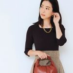 リブニットとツイードスカートをドッキングしたワンピースを着用するDomanistの吉田美帆さんのバストショット