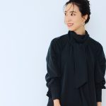 太めのタイがあしらわれた黒ワンピースを着用したDomanist 吉田美帆さんの上半身