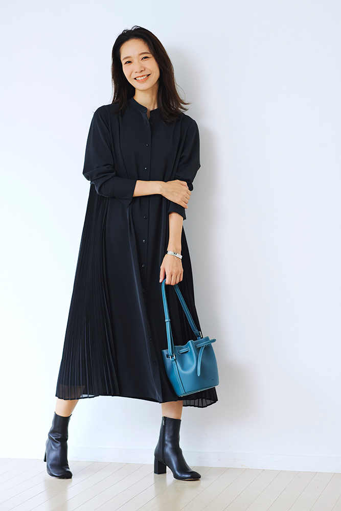 黒のシャツワンピースを着て、ヒールのあるブーツを履きブルーのバッグを持ったDomanistの井川加奈子さん