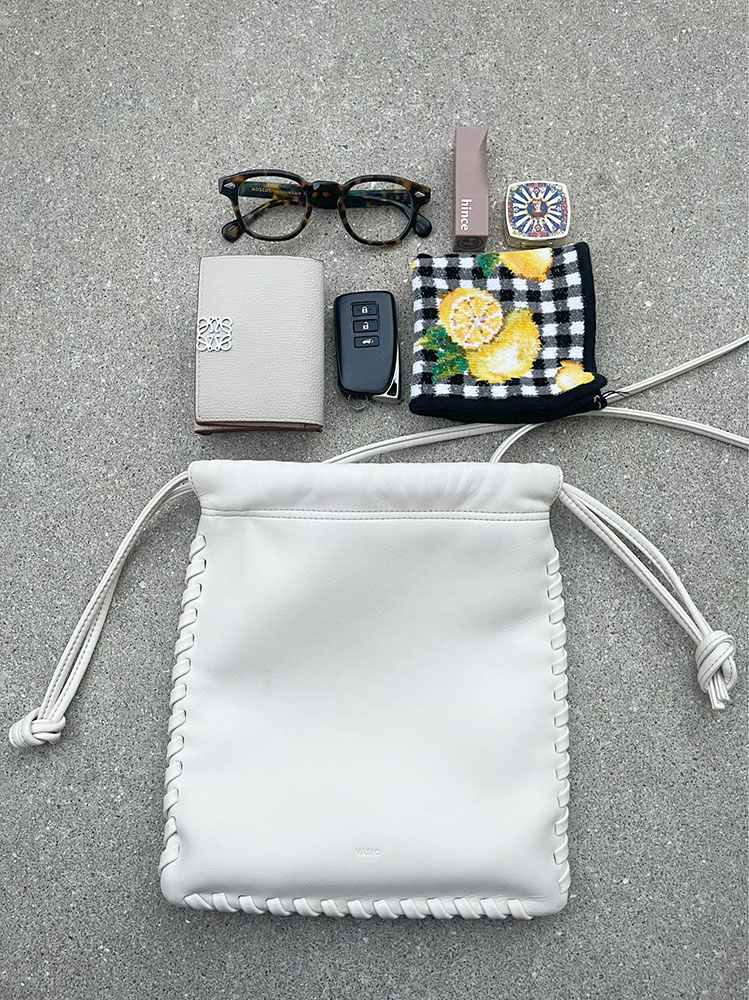 巾着型のバッグとミニ財布、メガネ、ハンカチ、車のキー、コスメ