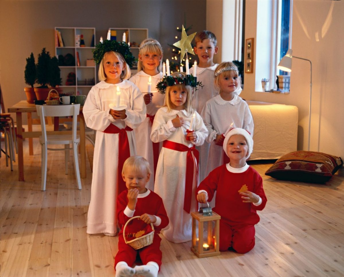 スウェーデンの子どもたちがクリスマス衣装を身に纏ってキャンドルを持っている様子