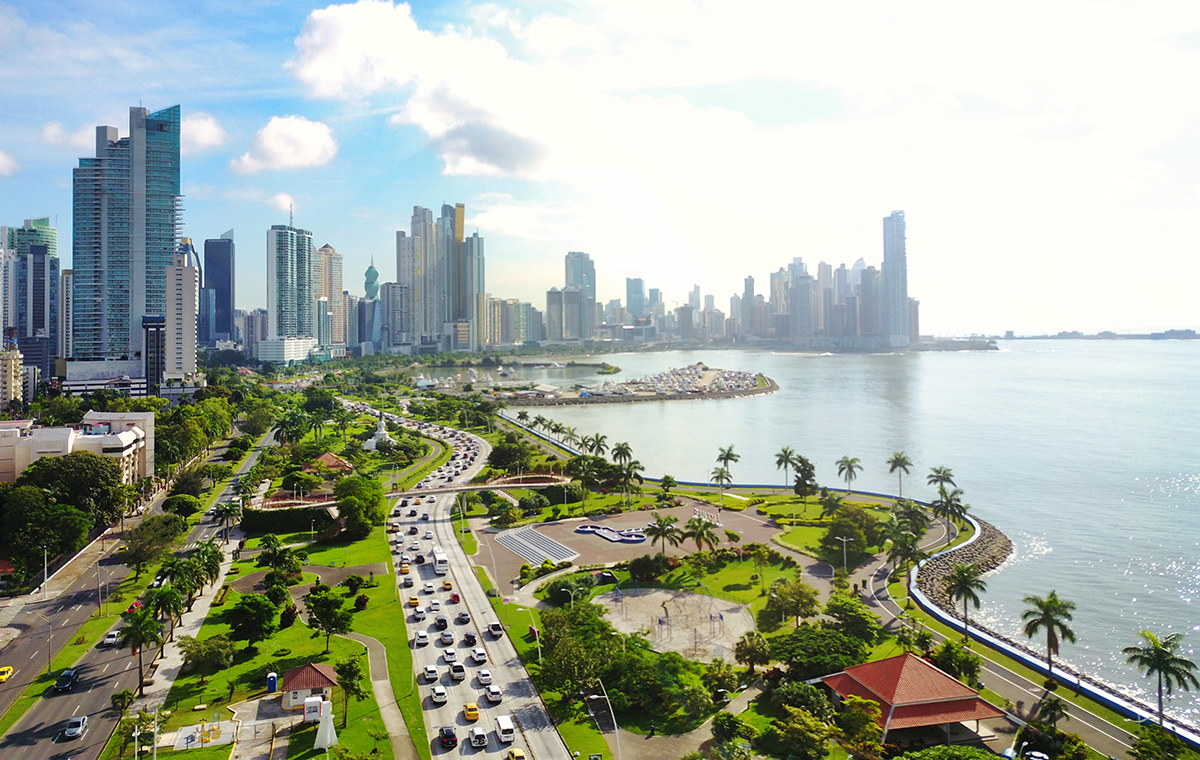 パナマの首都パナマシティーのビル街と海辺に椰子の木の並ぶ景色