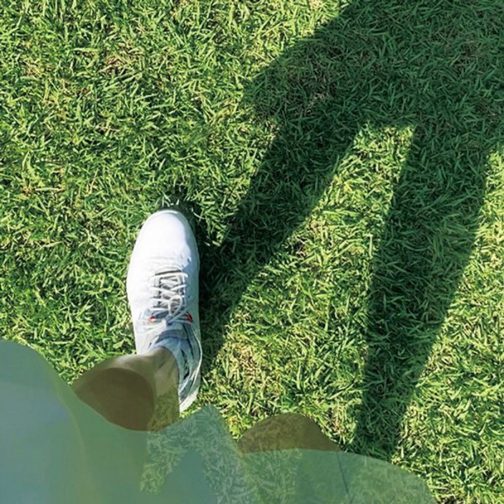 ゴルフのコースを歩く女性の足元