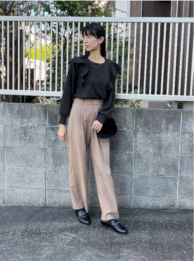黒ブラウスとベージュパンツを着ているドマーニスト 花田彩歌さんの写真