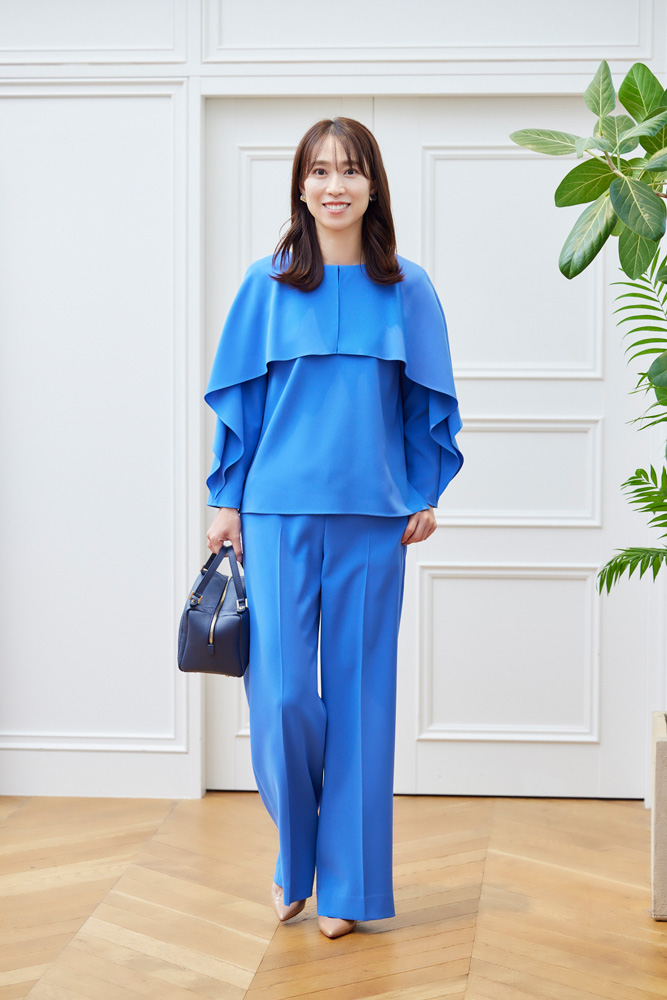 ブルーのブラウスとパンツのセットアップを着たドマーニスト 吉田美帆さんの全身ショット