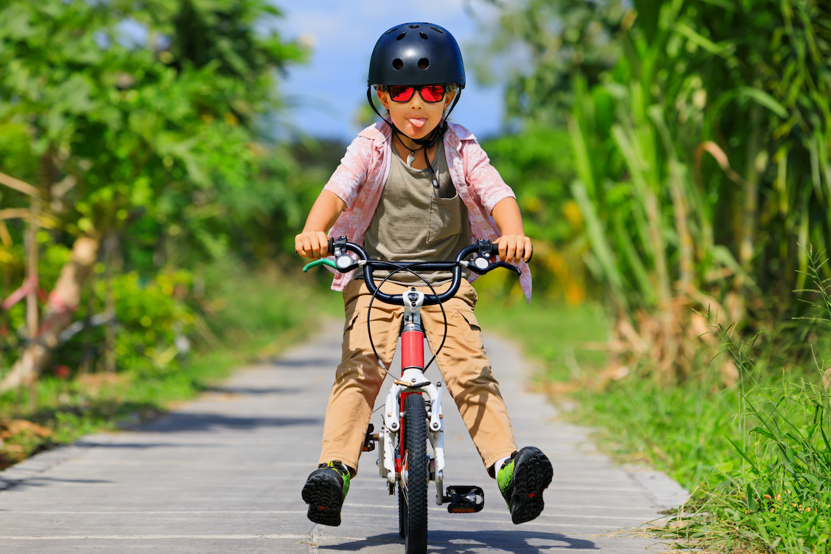 ヘルメットをかぶって自転車に乗るこども