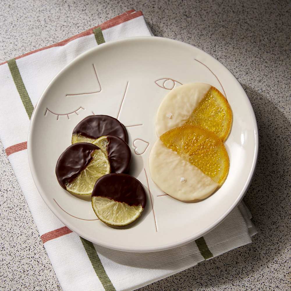 チョコレートが半分かかった輪切りの柑橘のお菓子2種が白い皿に盛られた写真