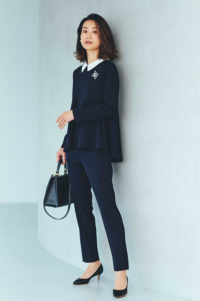 ネイビーの襟つきトップスとパンツのセットアップを着用したモデルの牧野紗弥さんの全身写真