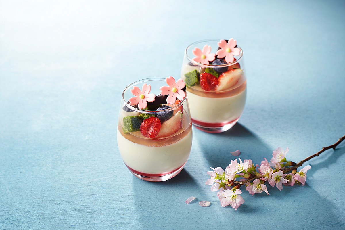 グラスにパンナコッタやフルーツが入って桜の飾りがついているデザート