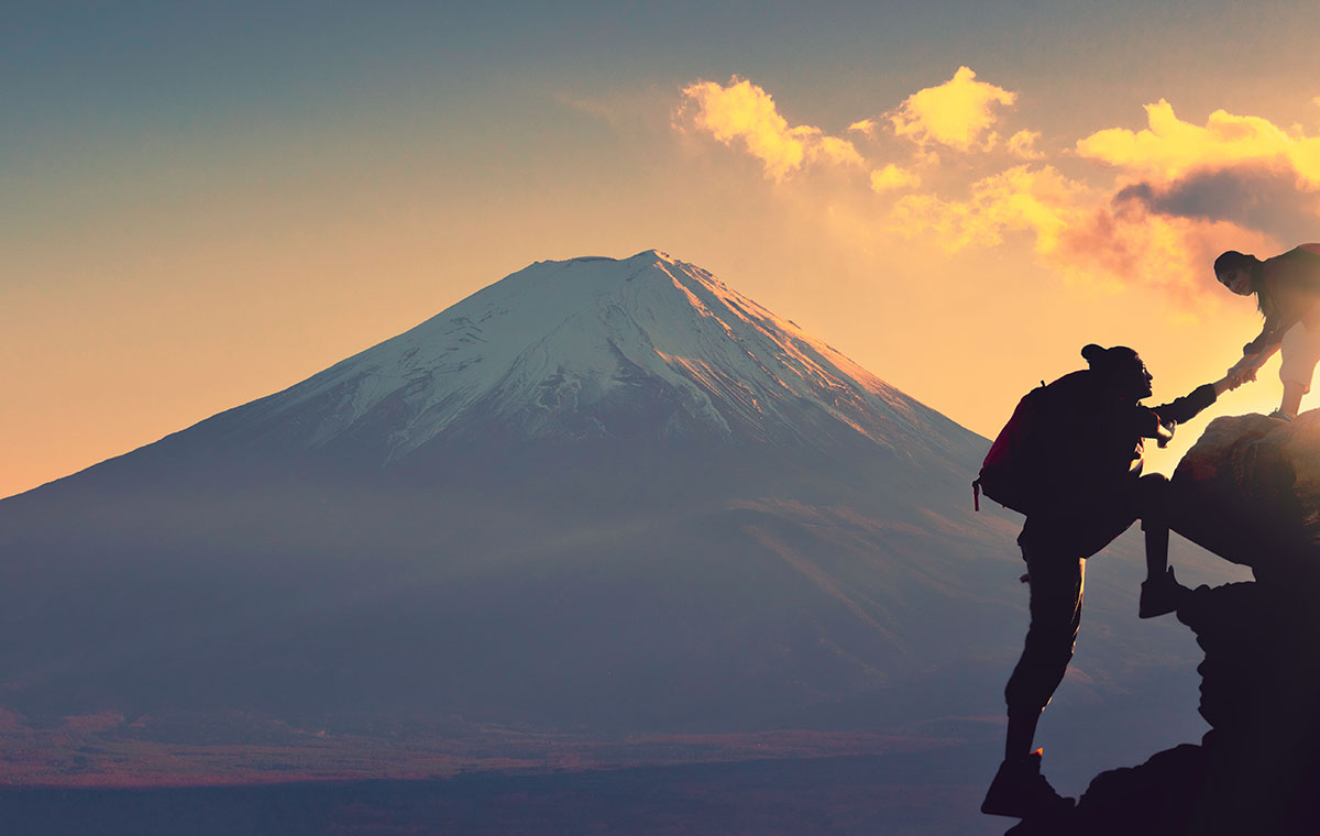 富士山を背景に登山をする男女カップル
