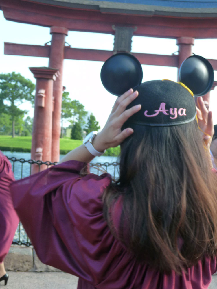 フロリダ・ディズニー・ワールドにて、ミッキーの耳つき帽子を被った女性の後ろ姿。帽子には「Aya」の文字