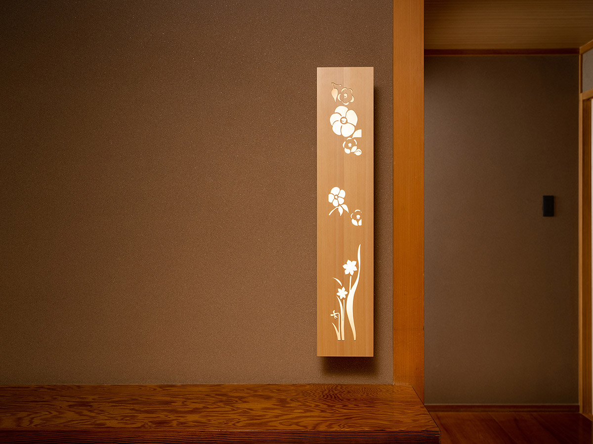 花模様が彫られた木の行灯が壁に取り付けられている写真