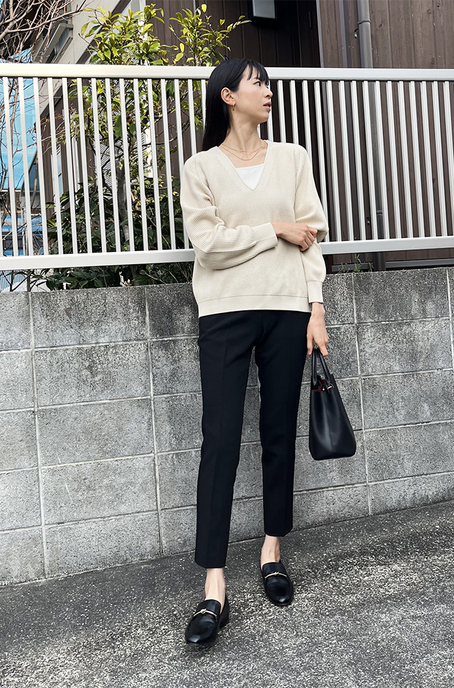 ベージュのセーターに白いインナー、黒パンツを着用した、ドマーニスト 花田彩歌さんの全身スナップ