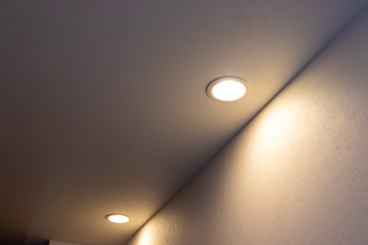 天井に埋め込まれたふたつのダウンライトが壁際を照らしている写真