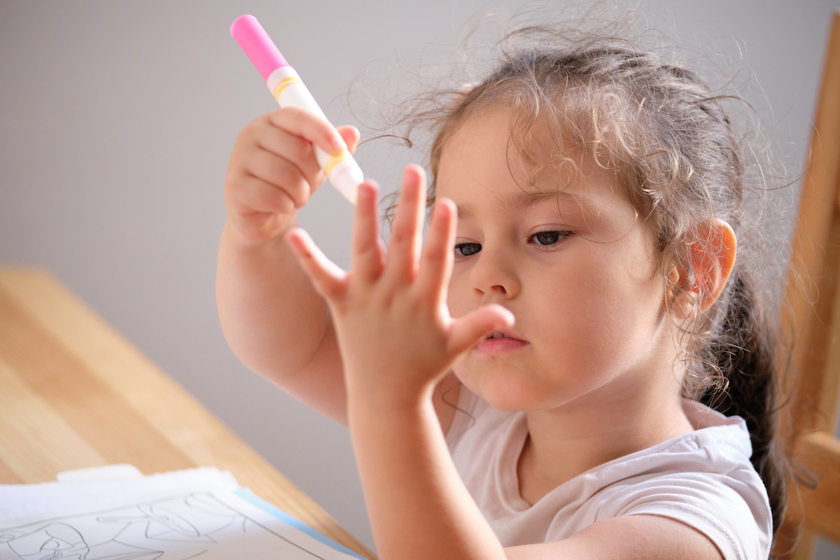 ピンクのペンを持っている子供のイメージ写真