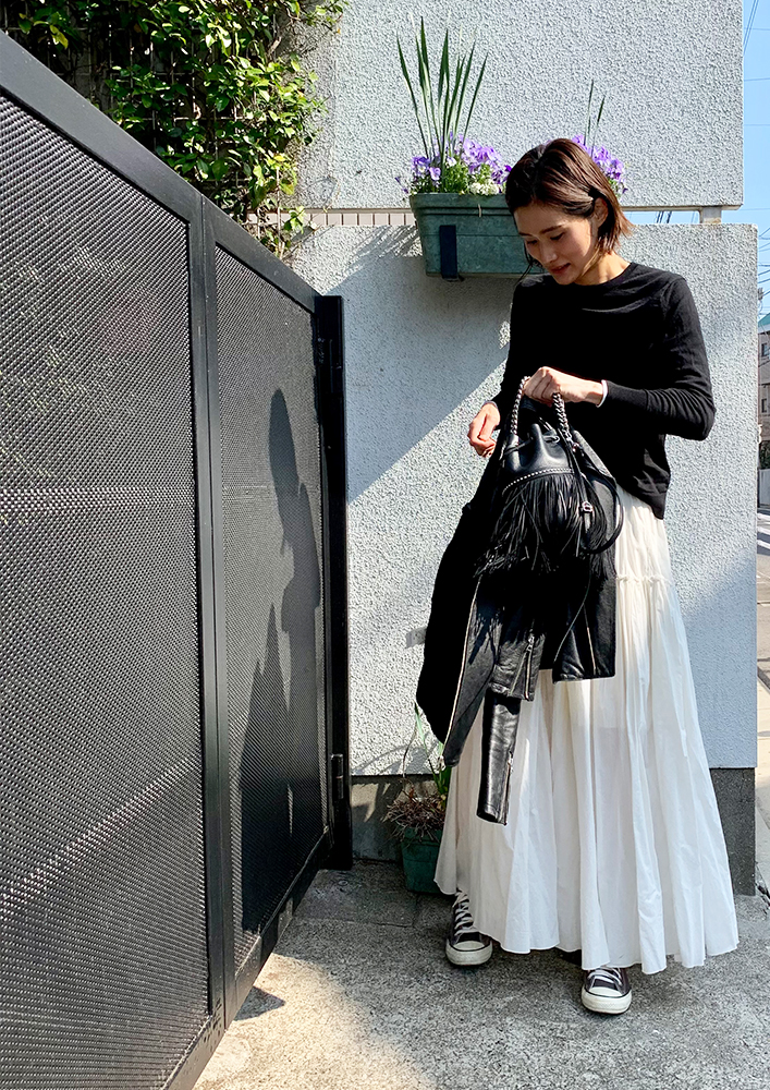 黒のロンTに白のティアードスカートを着用した、ドマーニスト 奥田陽子さんのスナップ写真