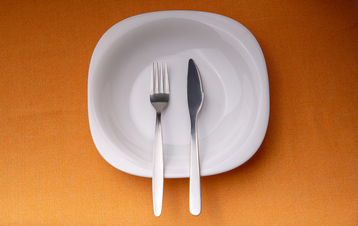 お皿にナイフとフォークが縦向きに揃えて置いてある様子の写真