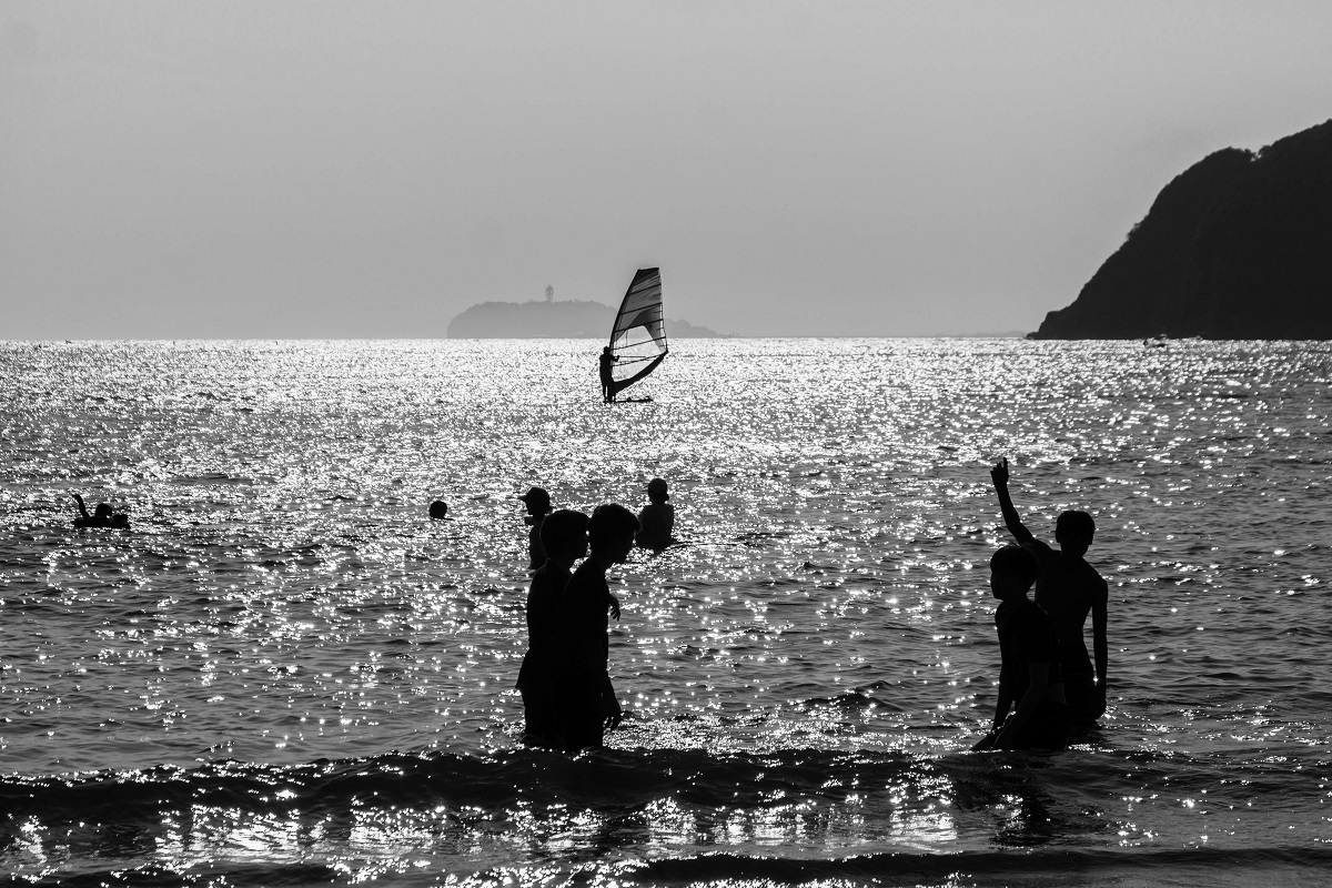 海で遊んでいる人たちのモノクロ写真