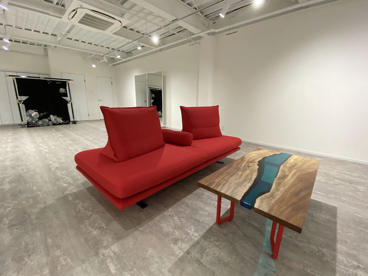 プロフィール写真　赤いソファと木のローテーブルが置かれた部屋