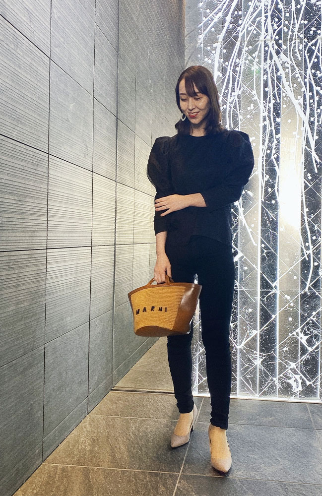 黒のバルーンスリーブトップスに黒パンツを着用した、ドマーニスト西和田亜由美さんのスナップ写真