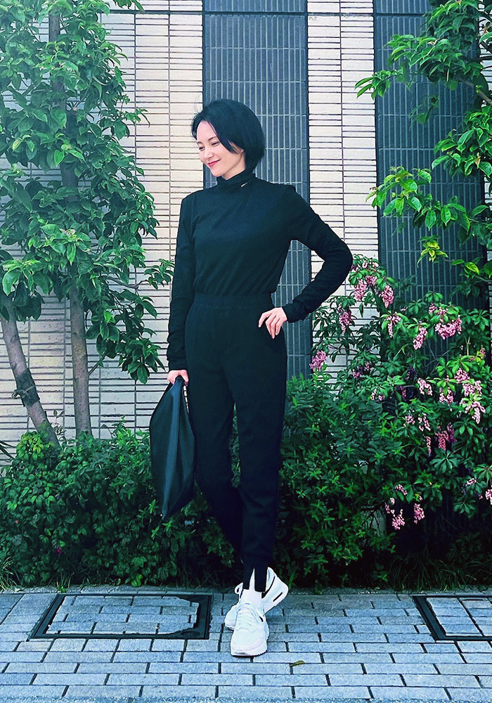 黒のトップスに黒のジョグパンツを着用した、ドマーニスト 鈴木まきさんのスナップ写真