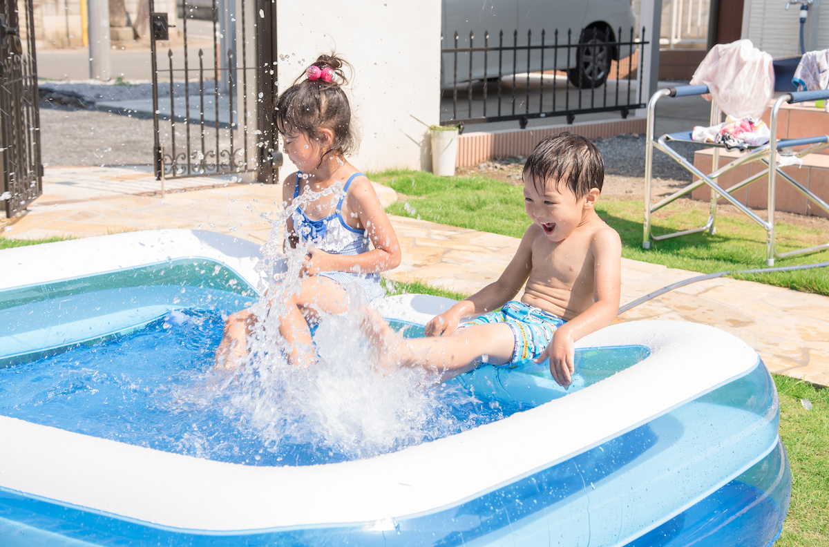 家庭のプールで遊ぶ2人の子供の写真