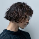 パーマがかかった女性がアンニュイな表情で写っている写真