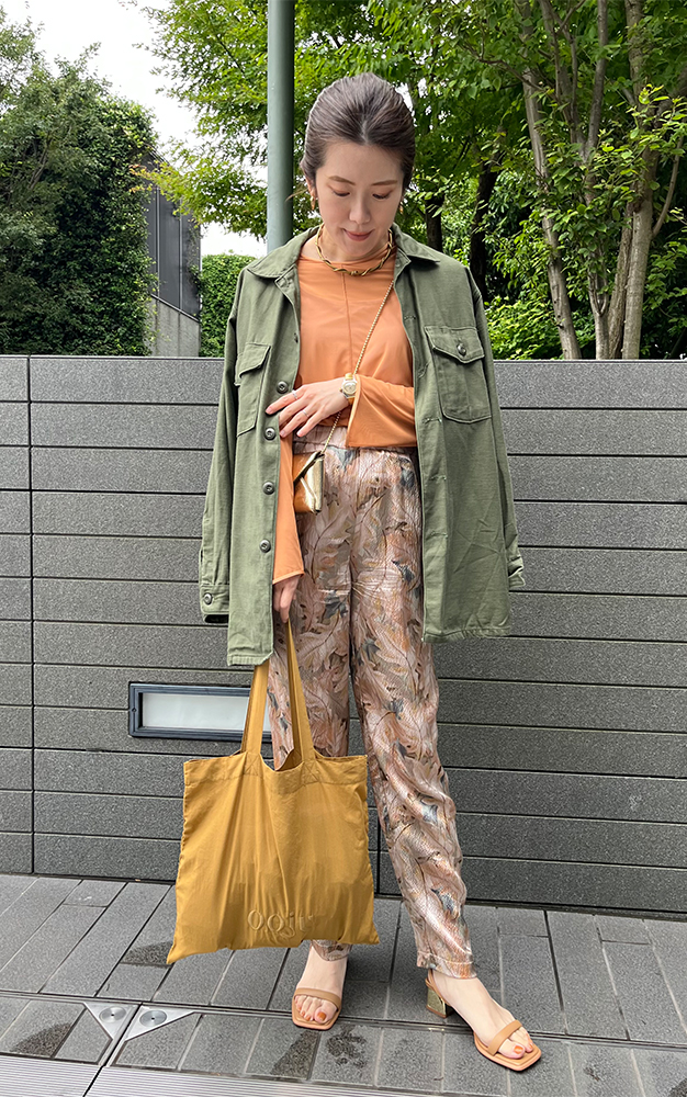 オレンジのシアートップスに柄パンツ、ジャケットを着用した杉本緑さんのコーデスナップ