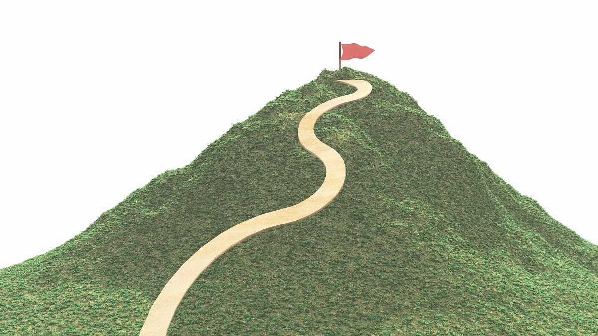 緑の山と山頂の赤い旗