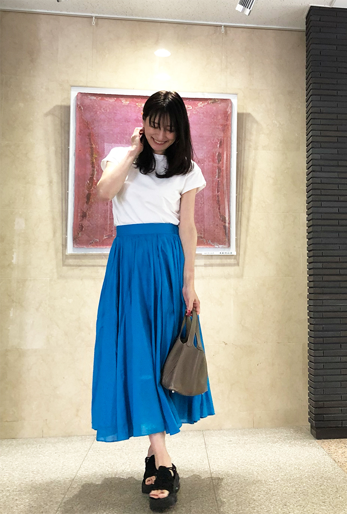 白Tに青いスカートを着用した、ドマーニラボメンバー 飯島美穂さんのスナップ写真