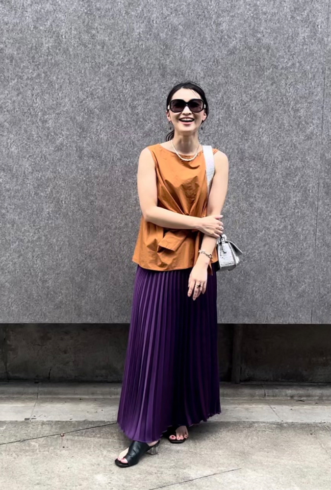 オレンジのタンクトップに紫のスカートを着用した、ドマーニラボメンバー 菱沼阿弥さんのスナップ写真