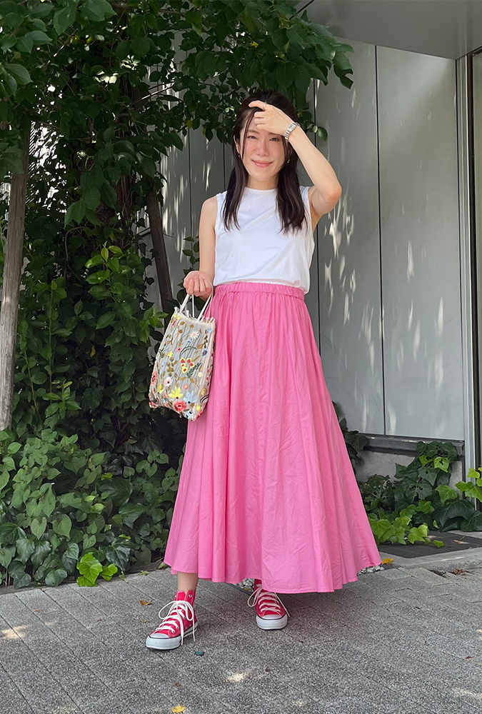 白いタンクトップにピンクのスカートを着用した、ドマーニラボメンバー 杉本緑さんのスナップ写真