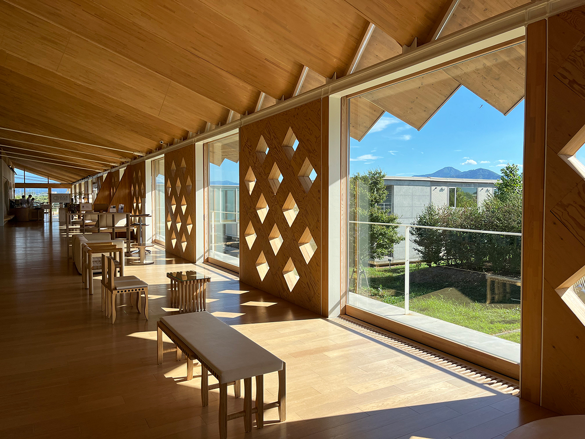 木造でできた施設の内観、大きな窓とベンチが並ぶ様子