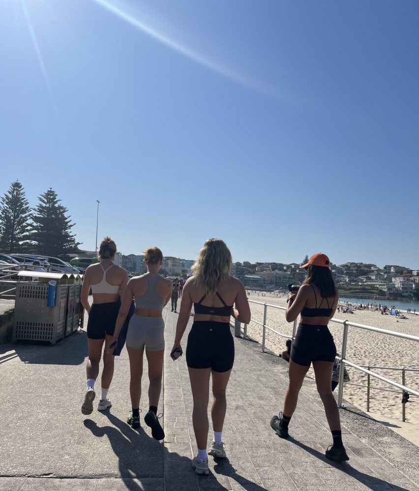 ボンダイビーチのビーチサイドを歩くトレーニングウェアを着た女性4人組