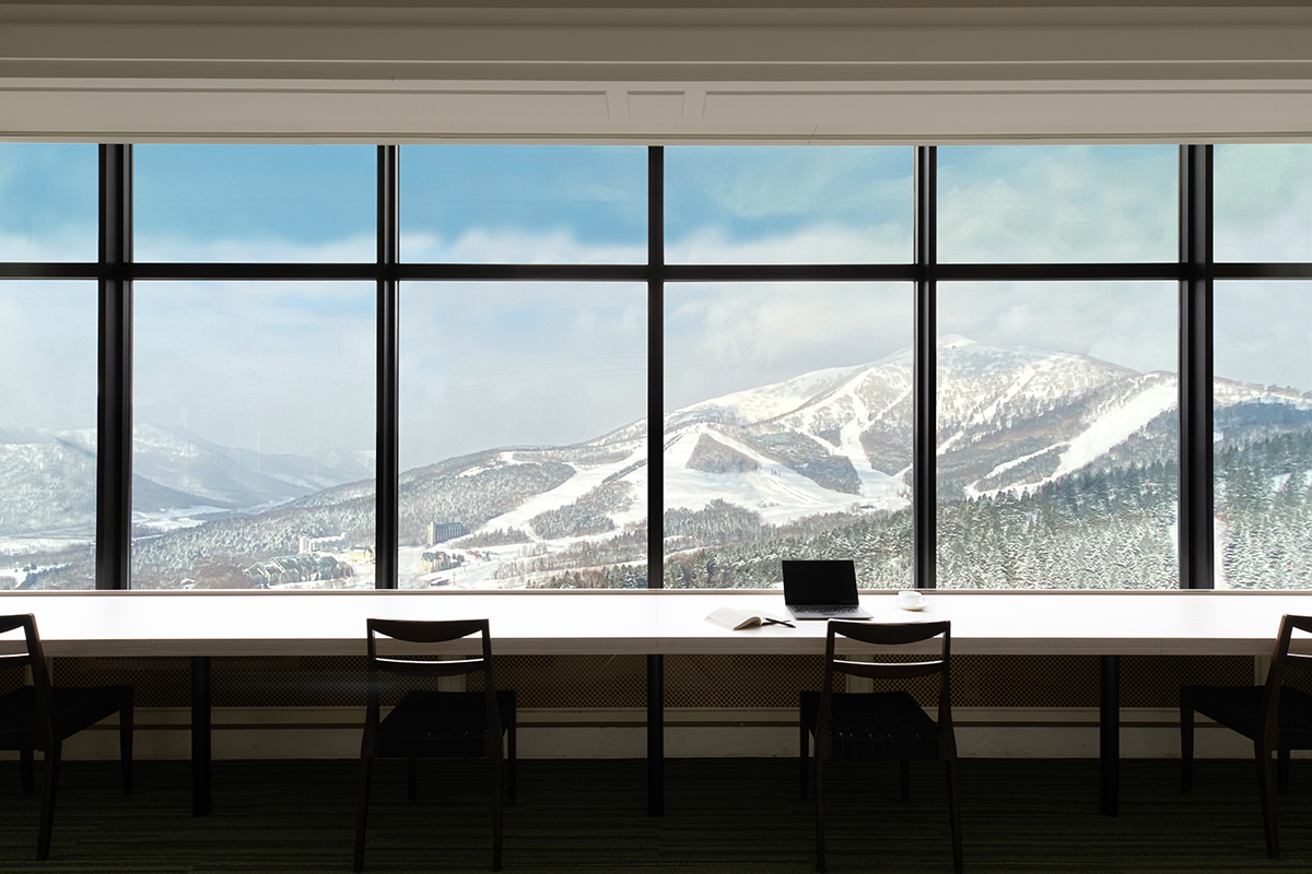 雪景色を望む窓際にカウンターのある部屋の写真
