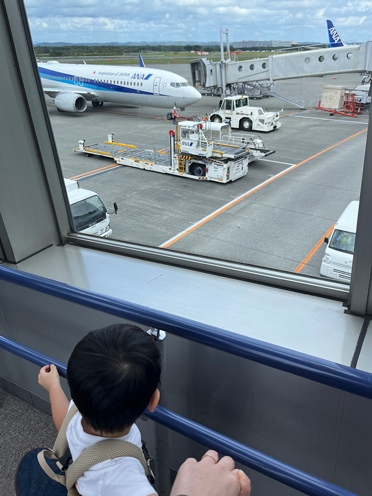 新千歳空港の窓から飛行機を眺める筆者の息子さん