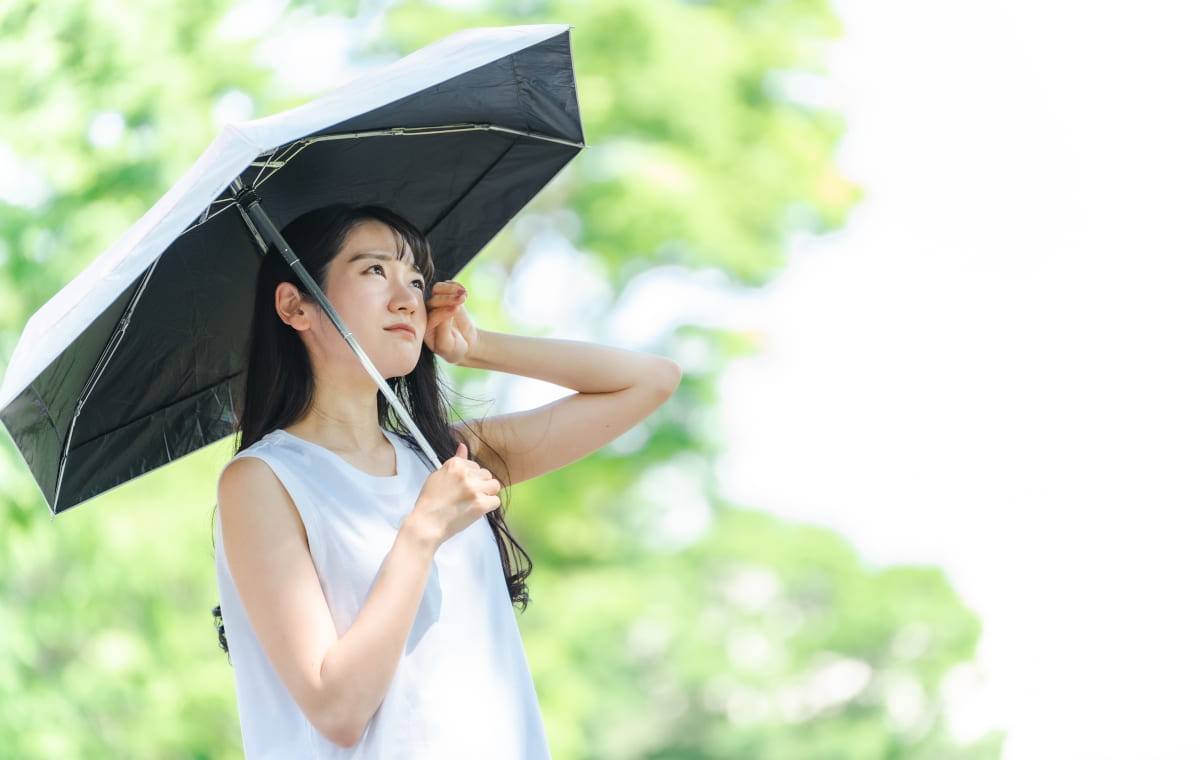 日傘をさして不満げな顔の女性