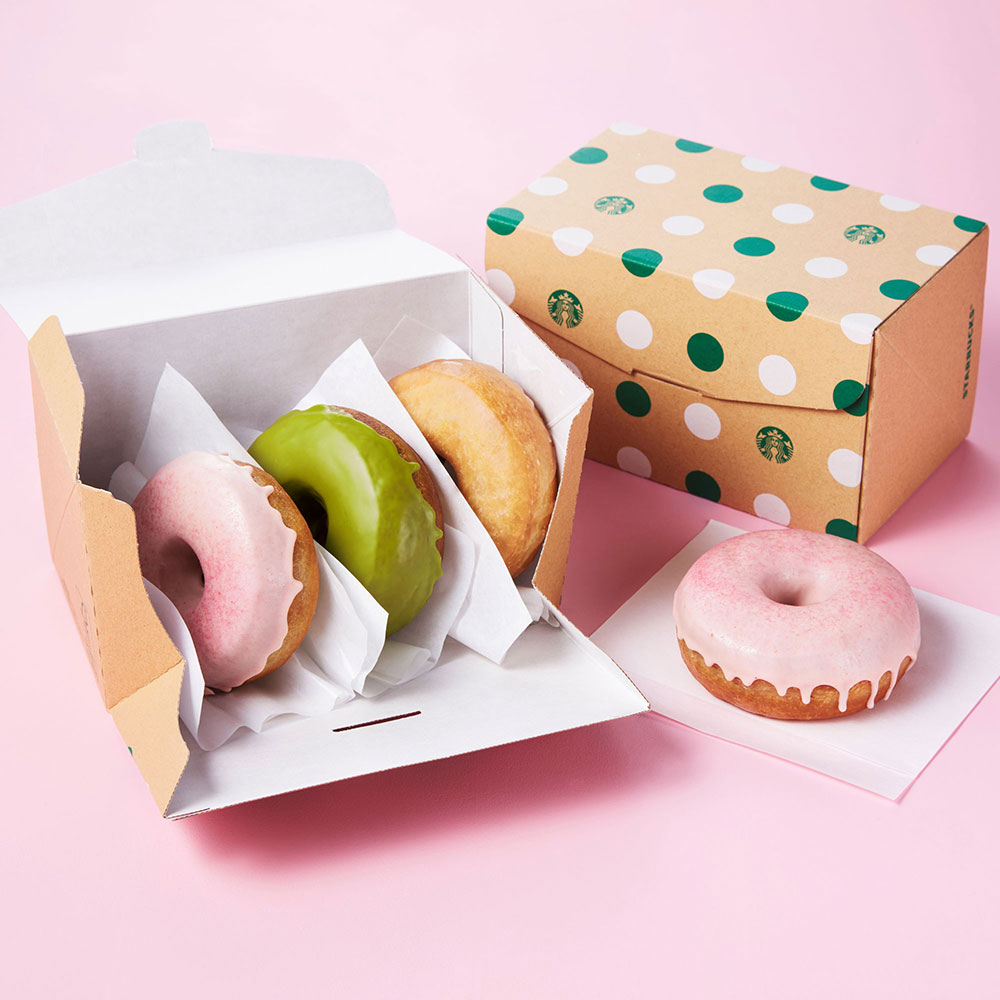 ボックスに入ったピンク、緑、ベージュのドーナツの写真