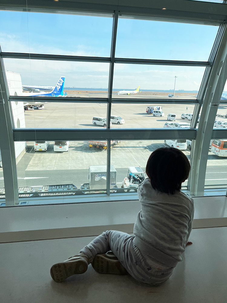 空港の窓から飛行機を眺める筆者の息子さん
